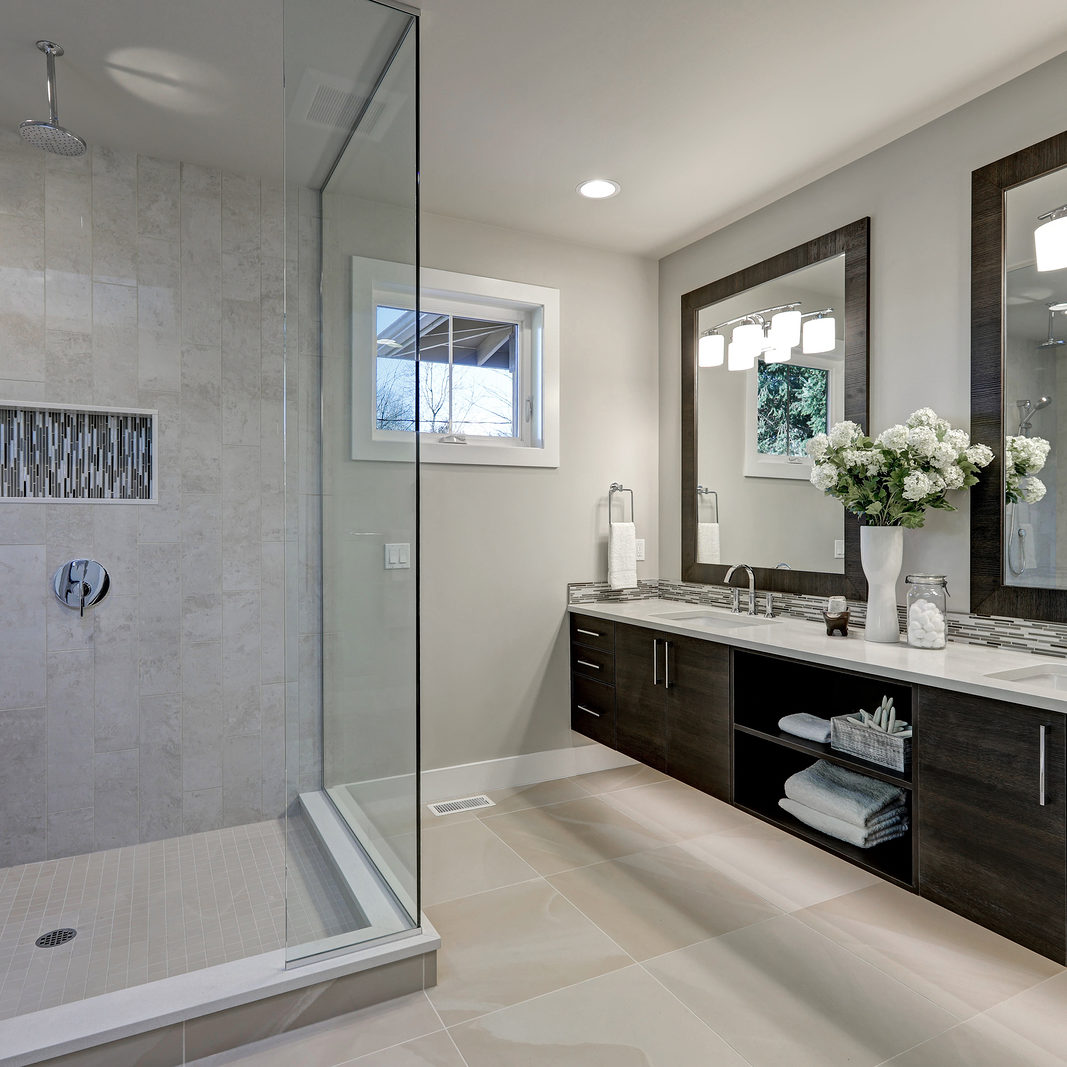 Spacious bathroom in gray tones with heated floors walk-in shower double sink vanity and skylights. Northwest USA